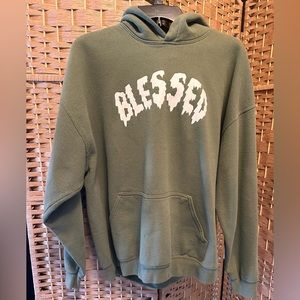 Green sweatshirt with blessed written across the chest.